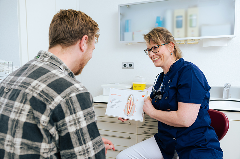 Dr. Weilandt klärt einen Patienten über die Wurzelbehandlung auf.
