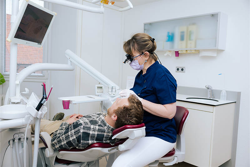 Frau Dr. Weilandt führ bei einem Patienten die Prophylaxe durch.