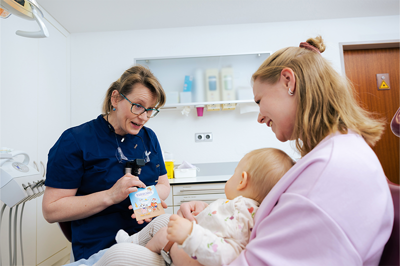 Dr. Weilandt berät eine Mutter bezüglich der Behandlung der Kinderzähne.