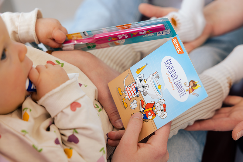 Ein kleines Kind hält ein Buch in der Hand.