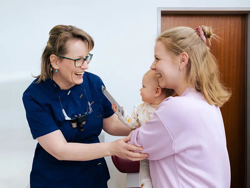 Fr. Dr. Weilandt begrüßt eine Patientin mit ihrem Kind.